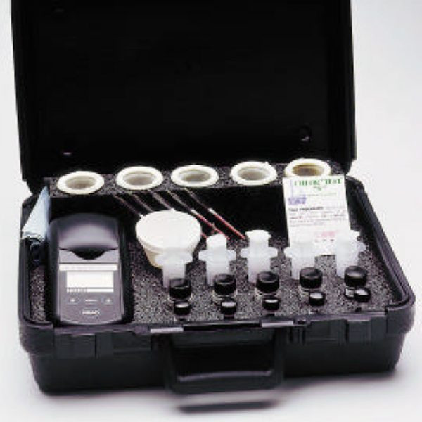 A technician performing a contamination test using a refill kit for chlorides, sulfates, and nitrates on a horizontal metal surface. The patented CHLOR*EXTRACT™ solution is being applied, showcasing its high retrieval accuracy. Industrial tanks and pipelines are visible in the background, highlighting the kit's application in real-world industrial environments.